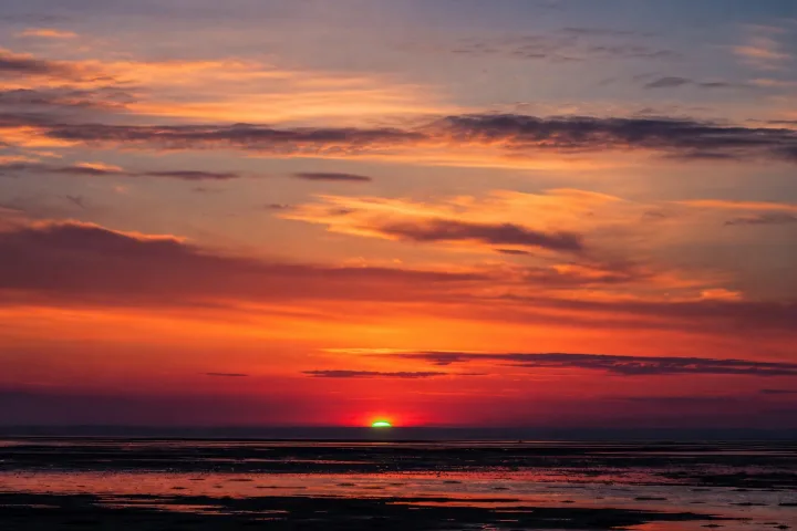 Lampo verde al tramonto sull'orizzonte marino, fotografico realistico
