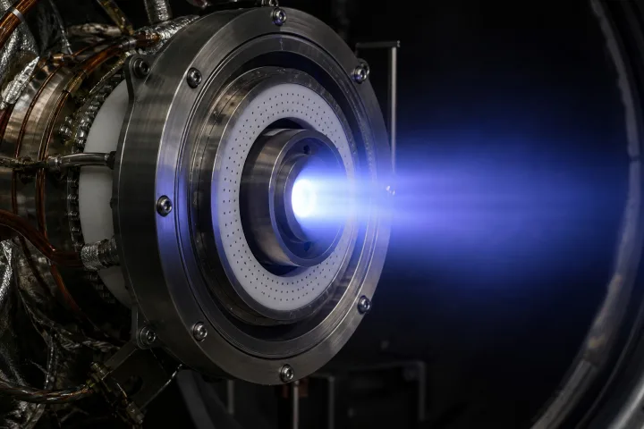 Dettaglio ravvicinato di un motore ionico spaziale con il caratteristico getto di ioni accelerati